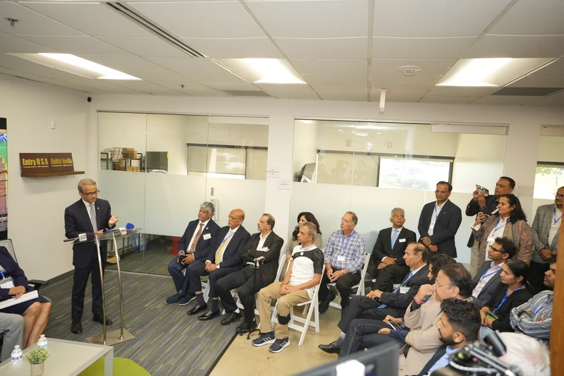 The speaker addresses seated and standing attendees in the USICC Business Lounge.