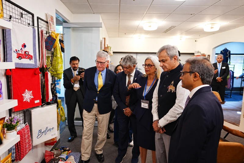 Guests inspect displayed textiles and products while touring the USICC showcase.