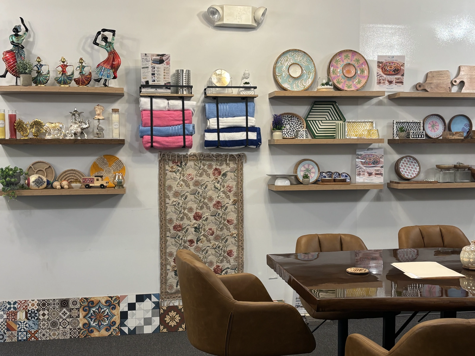 Shelves at USICC display textiles, decorative figures, patterned trays and tableware beside the Business Lounge.